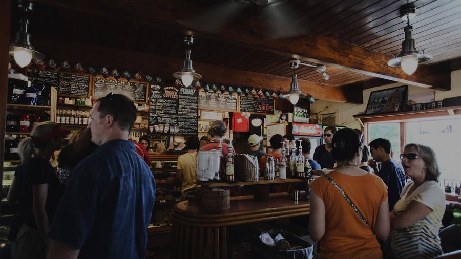 Interior de un local concurrido visto desde la barra